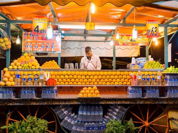 MARRAKECH, MOROCCO - OCTOBER 20, 2015: Unidentified man working on stand selling orange juice in Djemaa el Fna square central Marrakech, Morocco.